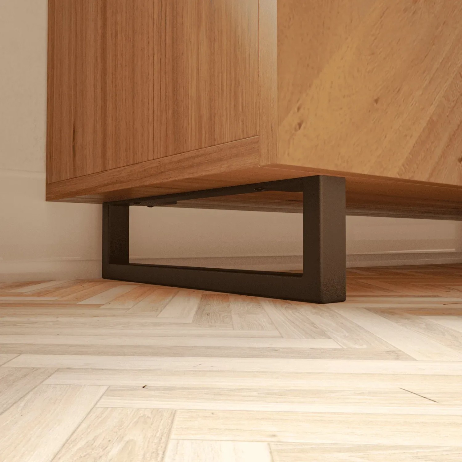 Schwarze HEVVA Möbelfüße GRAZ (2er Set) unter Holzmöbel auf hellem Holzboden.