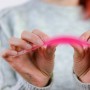 Hände biegen ein pinkes Knicklicht, das zu leuchten beginnt. Bunter Leuchtstab für Partys, Festivals & Kinder.