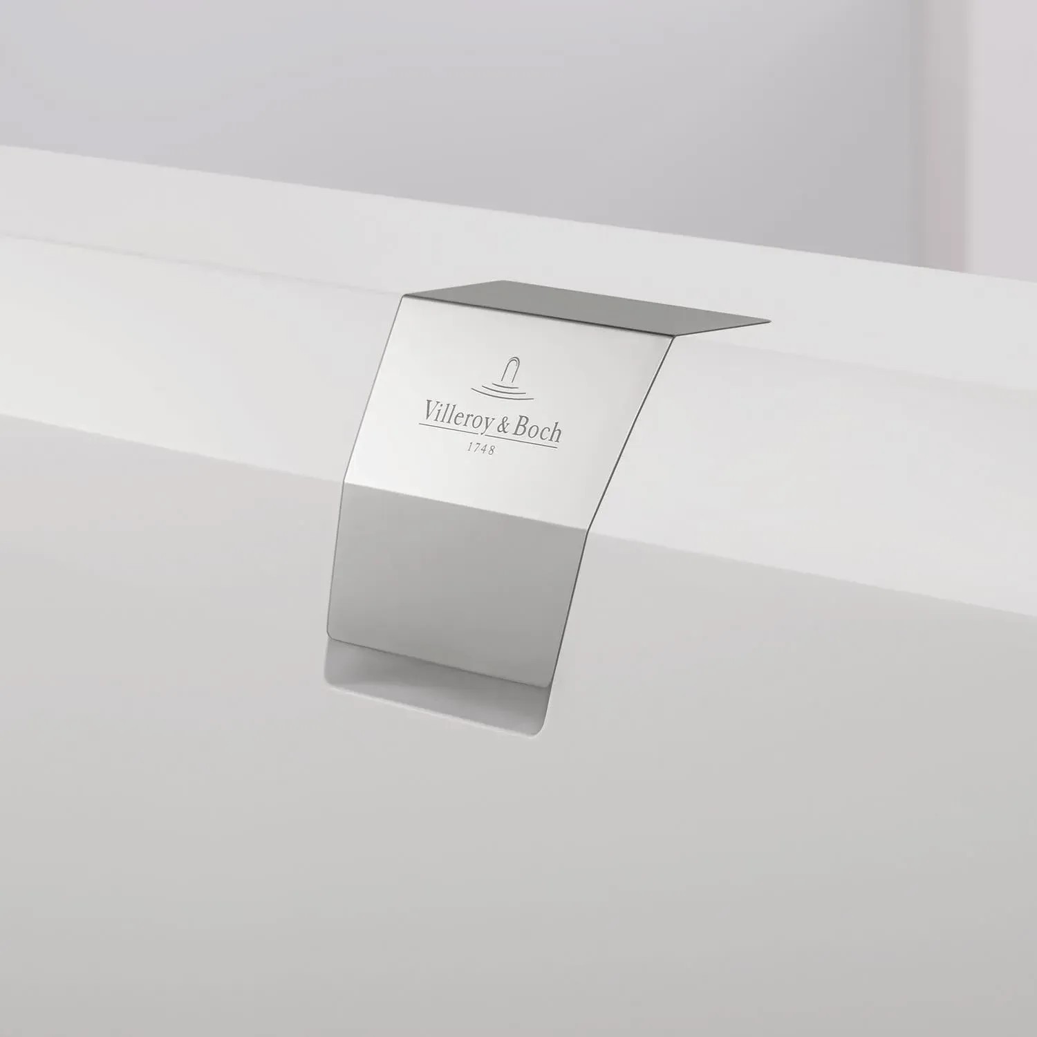 Detailaufnahme: Villeroy & Boch Squaro Edge 12 Duo Badewanne, weiße Quaryl-Badewanne mit verchromtem Überlauf.