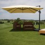 Cremefarbener MCW Ampelschirm 3x3m mit Aluminiumgestell und Ständer über Gartenmöbeln auf Rasen.