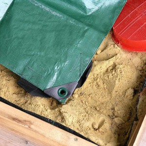 Grüne Sandkastenabdeckung 150x150 cm schützt Sand vor Schmutz und Laub.
