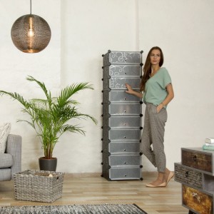 Relaxdays Schuhregal, schwarz, 10 Ebenen, transparente Türen mit Dekor. Frau zeigt schlankes Stecksystem im Flur.