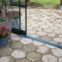 Detailaufnahme: Offene Schiebetür des grünen Halls GardenRoom Gewächshauses mit Pflanzen.