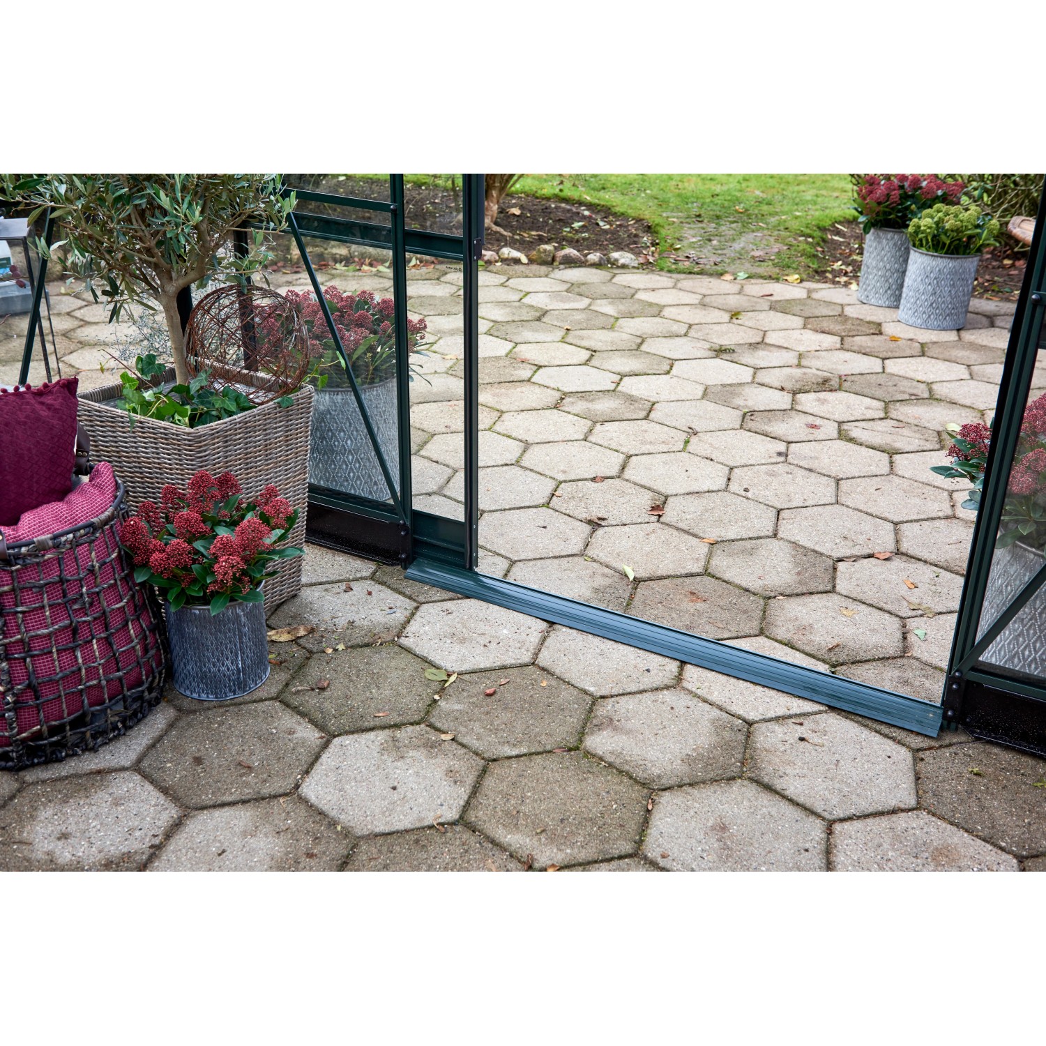 Detailaufnahme: Offene Schiebetür des grünen Halls GardenRoom Gewächshauses mit Pflanzen.