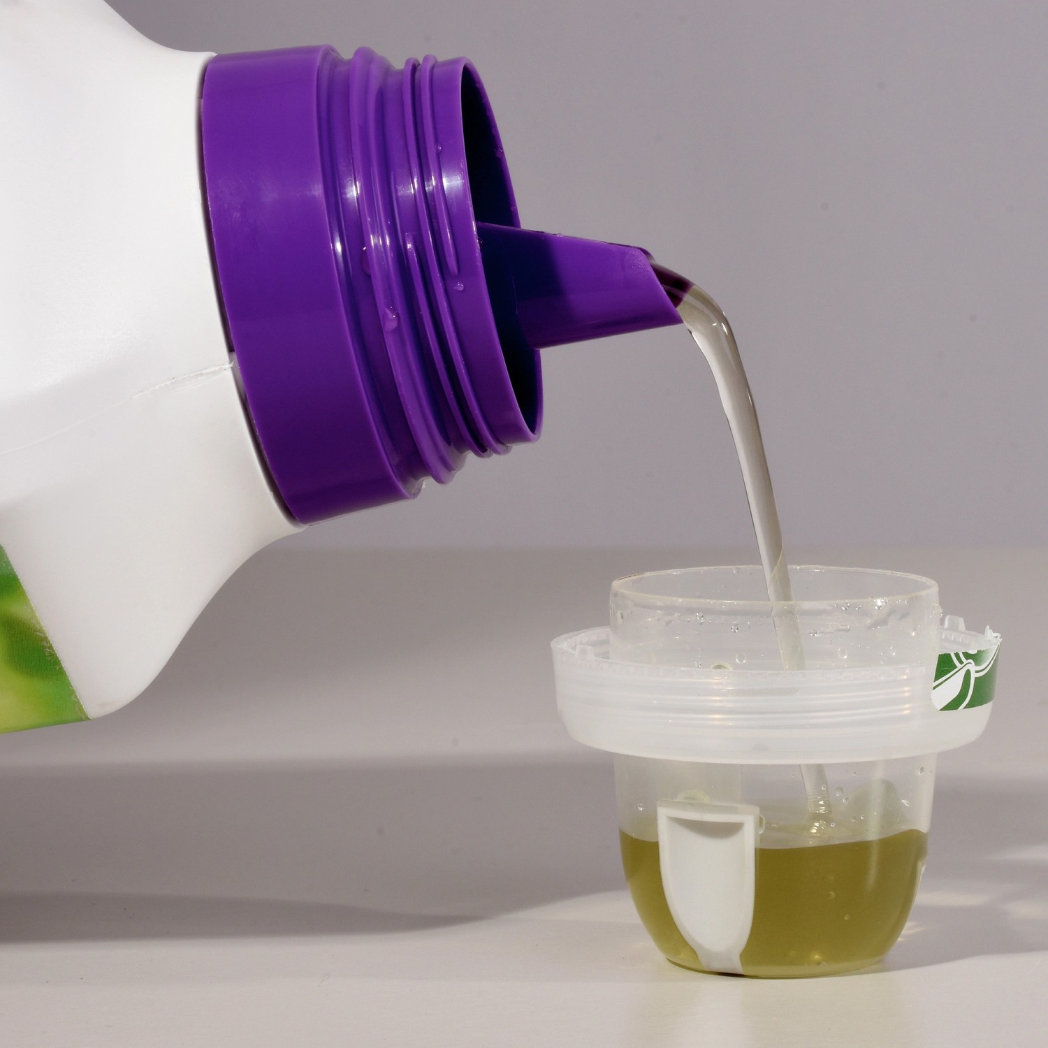 Compo Blühpflanzendünger: Flüssigdünger wird in Dosierkappe gegossen.