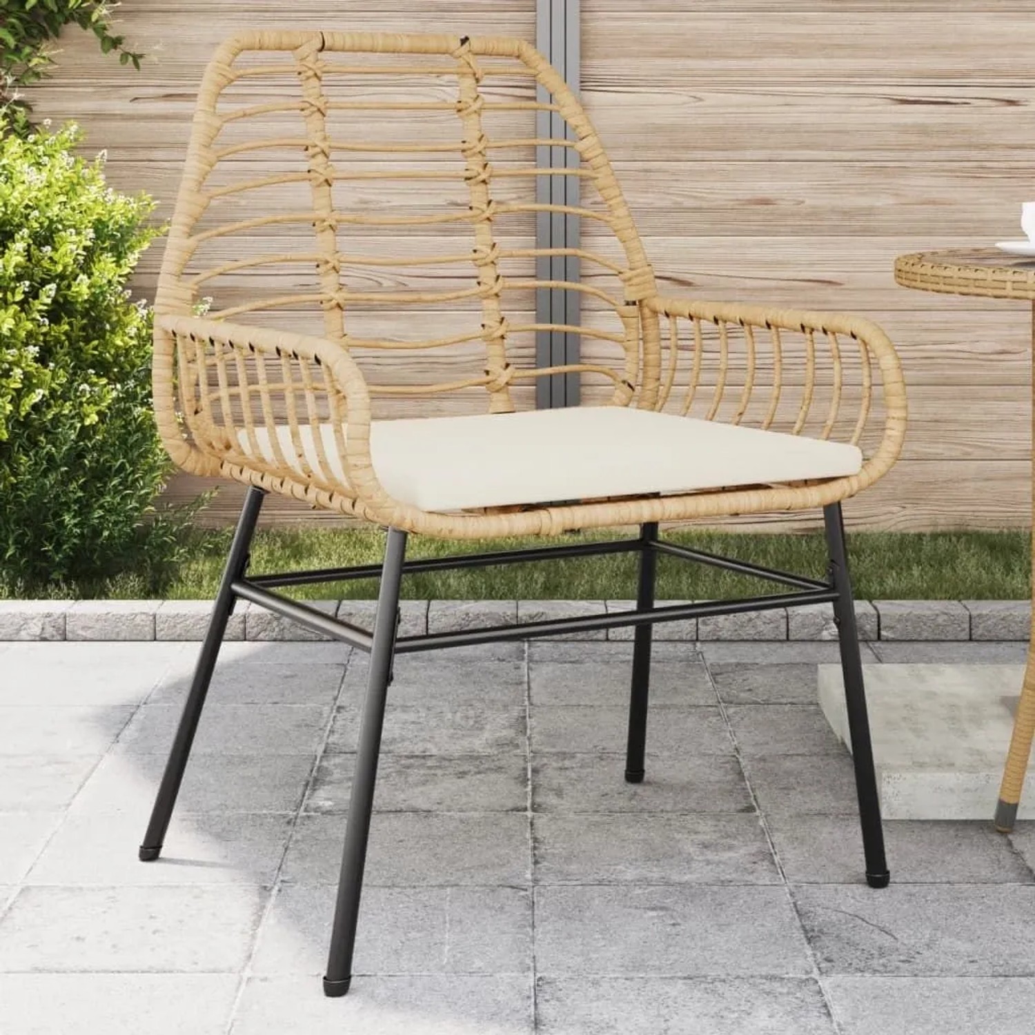 Brauner Poly Rattan Gartenstuhl mit cremeweißem Kissen auf Terrasse. Robustes Stahlgestell für Outdoor.