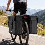 Schwarze Wiltec Doppel-Gepäckträgertasche 30L am Fahrrad auf Bergstraße. Wasserresistente Fahrradtasche für Touren.