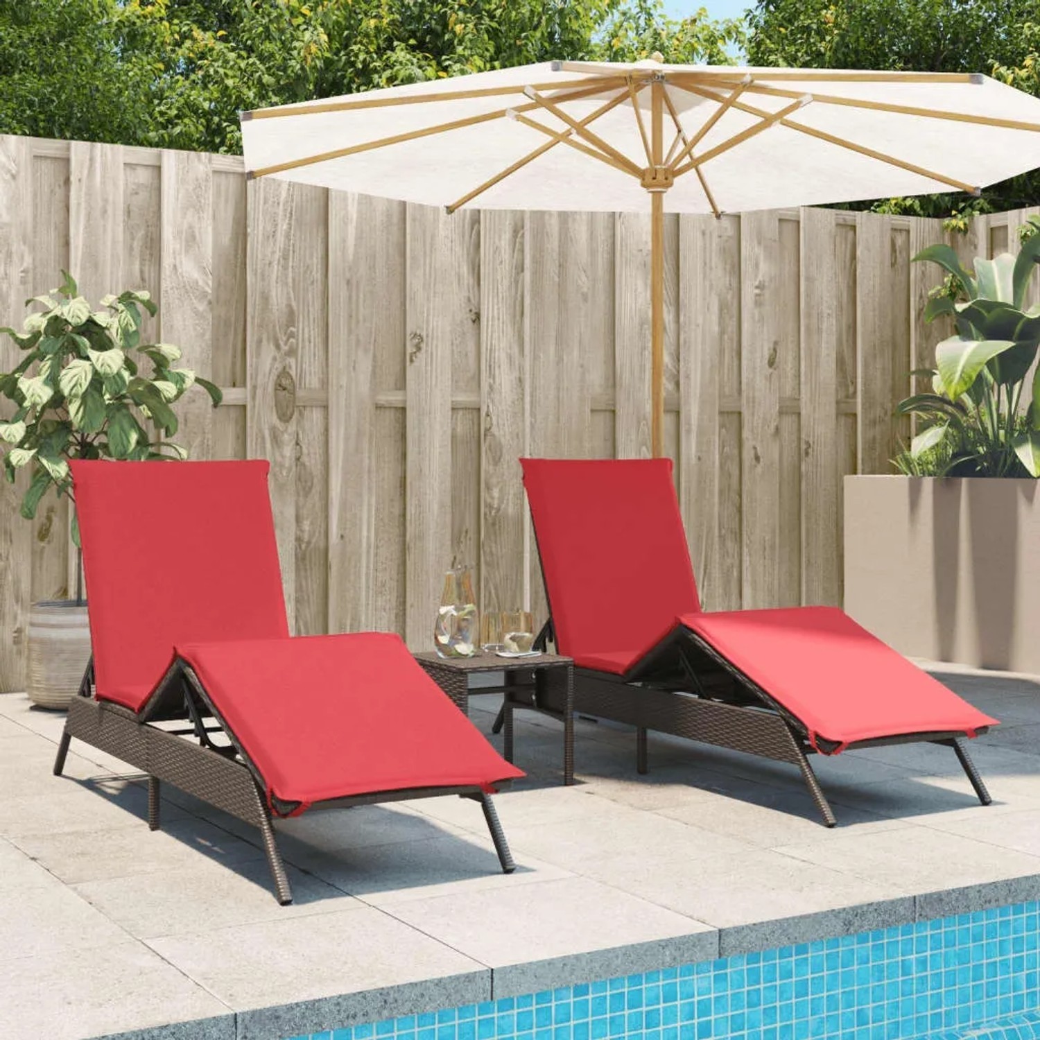 2 braune Poly Rattan Sonnenliegen mit roten Auflagen und kleinem Tisch für Garten oder Terrasse.