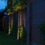 Schwarzer QAZQA Gartenstrahler mit Kabel beleuchtet Pflanzen am Zaun. IP65 wetterfest.