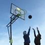 EXIT Galaxy Basketballkorb grün/schwarz mit spielenden Kindern vor blauem Himmel.