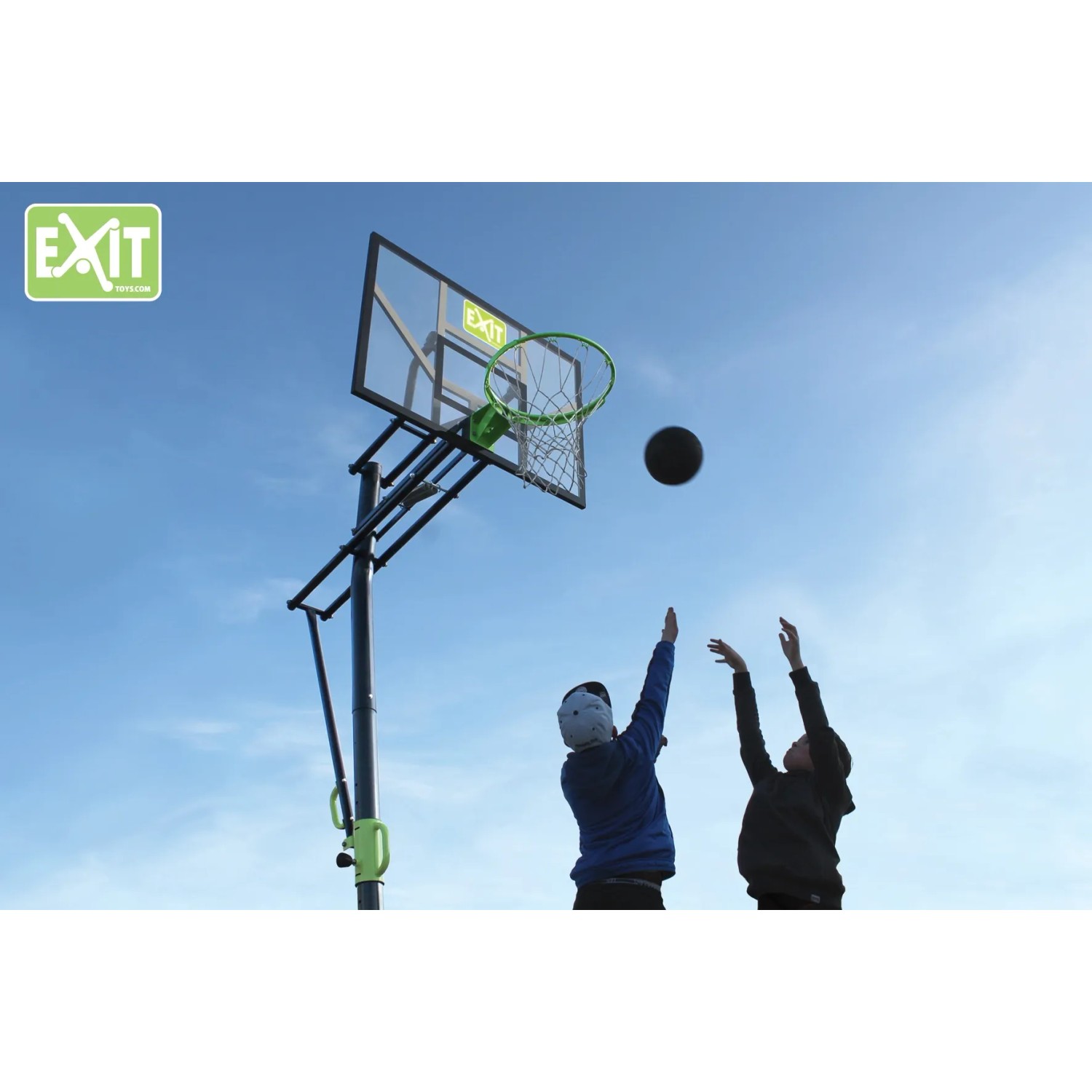 EXIT Galaxy Basketballkorb grün/schwarz mit spielenden Kindern vor blauem Himmel.