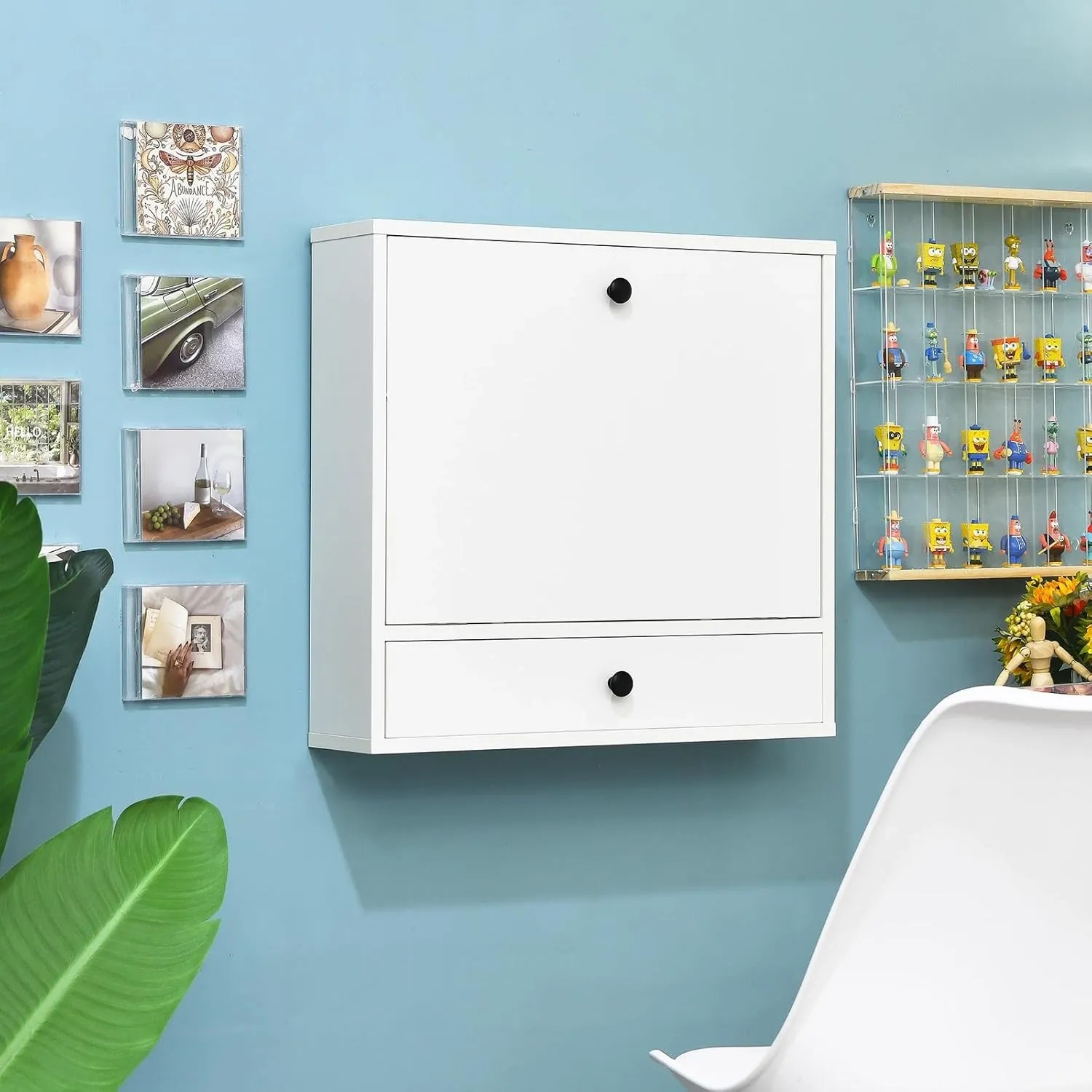 Weißer Costway Wandklapptisch mit Schublade und Ablagefächern, geschlossen an blauer Wand. Ideal als platzsparender Schreibtisch.