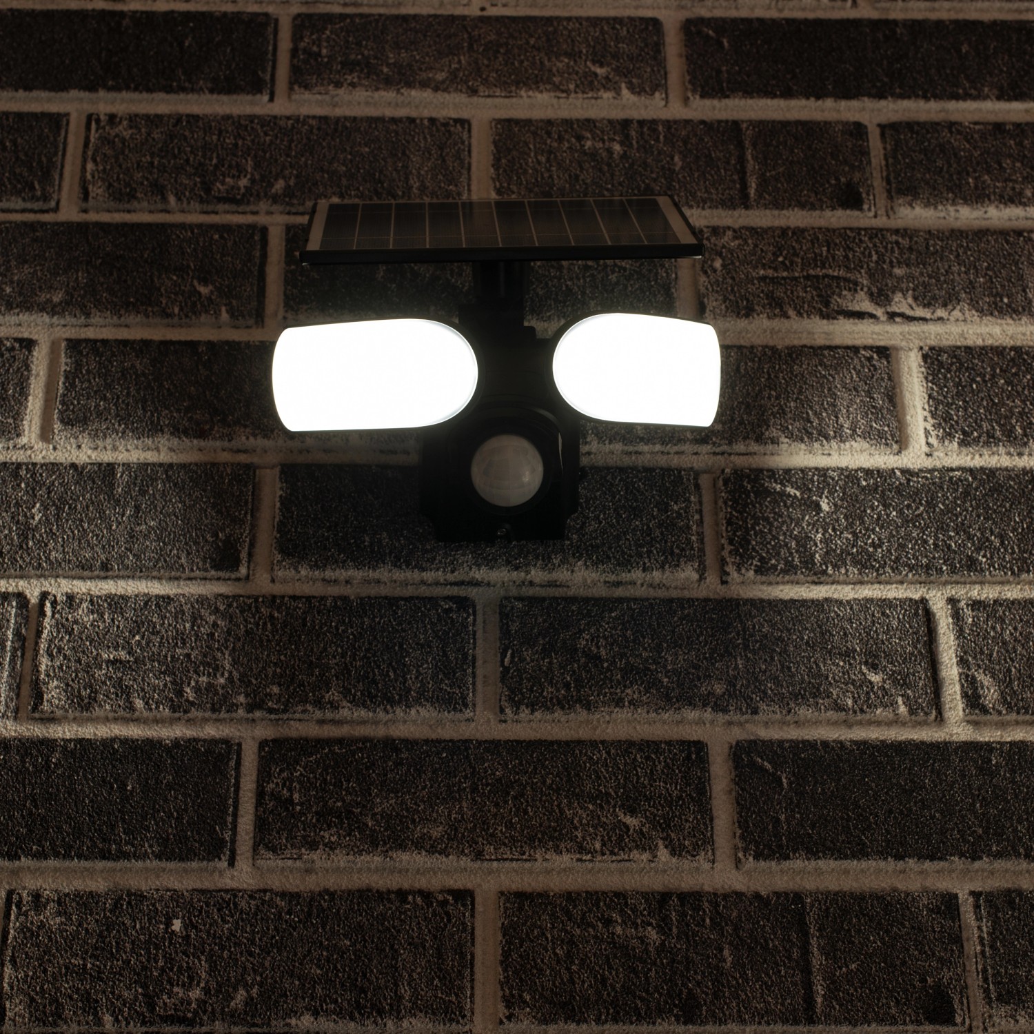 LED-Solar-Außenleuchte Botshabelo mit Sensor an einer Backsteinwand. Solar-Wandleuchte mit Bewegungsmelder.
