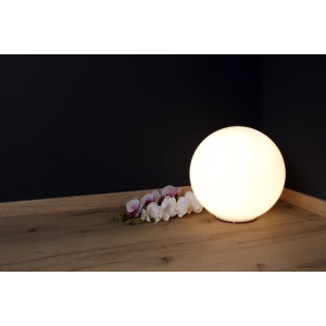 Weiße Luce Design Tischleuchte City, 35 cm Durchmesser, mit Blumen auf einem Tisch.