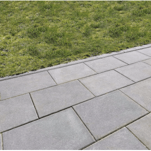 Graue Gehwegplatten 60x40 cm mit Fase verlegt neben Rasenfläche.