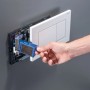 Hand schiebt blauen Geberit DuoFresh Stick in den Mechanismus einer weißen Sigma WC-Drückerplatte.
