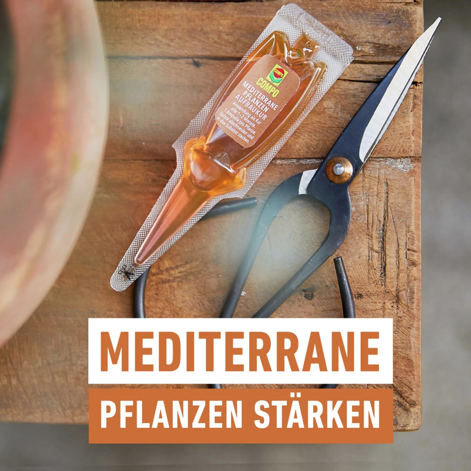 Compo Mediterrane Pflanzen Aufbaukur mit Schere auf Holzuntergrund. Dünger für mediterrane Pflanzen.