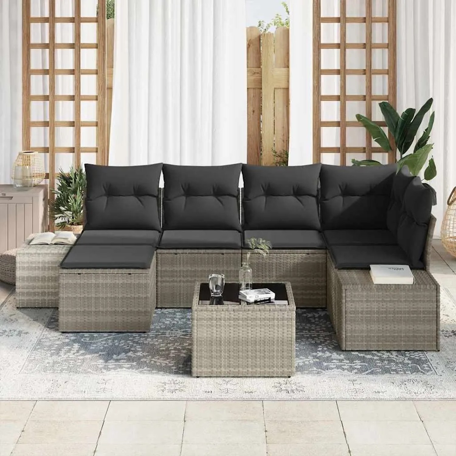 Hellgraues 7-teiliges Garten-Sofa-Set aus Poly Rattan mit grauen Kissen und Tisch.