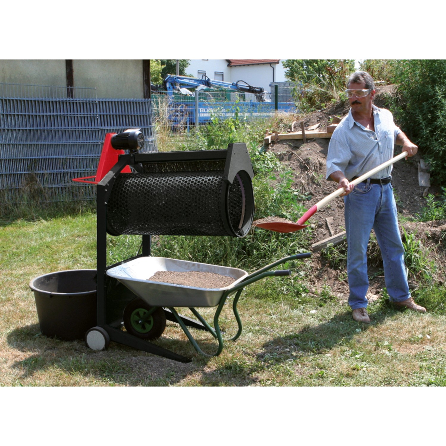 Scheppach Gartenrollsieb RS 400 beim Sieben von Erde in Schubkarre. Kompostsieb mit Mann.