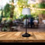 Schwarze LED Solar Tischleuchte Emmi von Näve, Ø 13 cm, 38 cm hoch, auf Holztisch im Außenbereich.