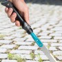 Gardena Fugenkratzer im Einsatz zum Entfernen von Unkraut zwischen Pflastersteinen.