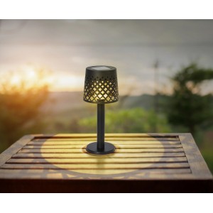 Schwarze, matte Globo LED Solarleuchte (Ø 9 cm) aus Kunststoff mit Gitterschirm auf Tisch.