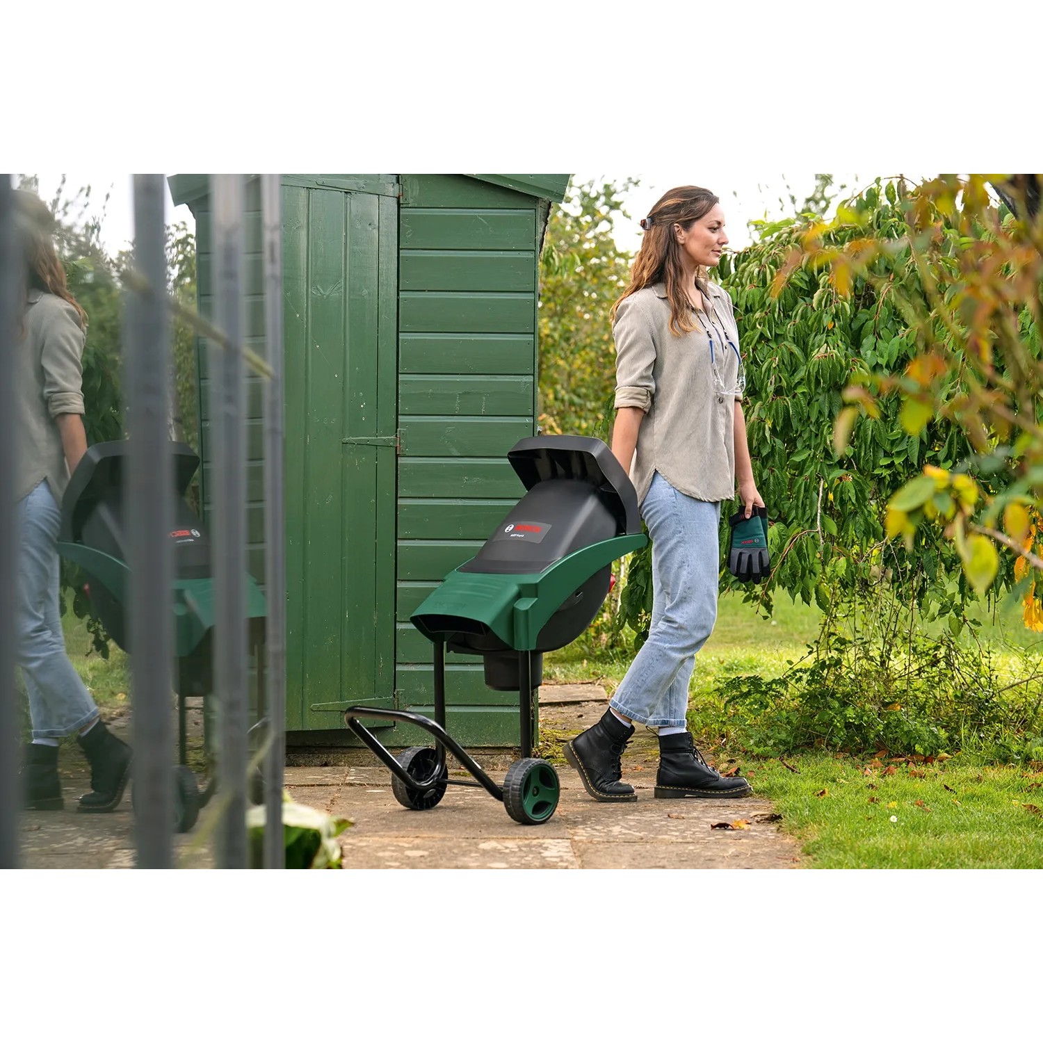 Bosch AXT Rapid 2200 Messerhäcksler im Einsatz im Garten mit Bedienerin.