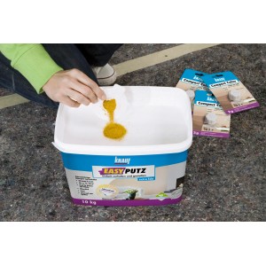 Knauf Easyputz Eimer mit Honiggelb Compact Color Farbpigmenten beim Einrühren.