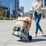 Blaue klappbare Relaxdays Sackkarre aus Stahl, 70 kg Tragkraft, beladen mit Kiste und Taschen, von Person geschoben.
