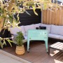 Axi Kühlwagen Retro Mint 76 l auf Terrasse mit Lounge-Möbeln und Tisch.