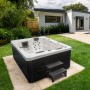 Home Deluxe Outdoor Whirlpool White Marble mit Treppe und Abdeckung im Garten.