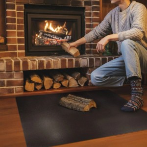 Schwarze Tulup Funkenschutzplatte aus Metall (100x80 cm) unter Kaminofen als Brandschutz.