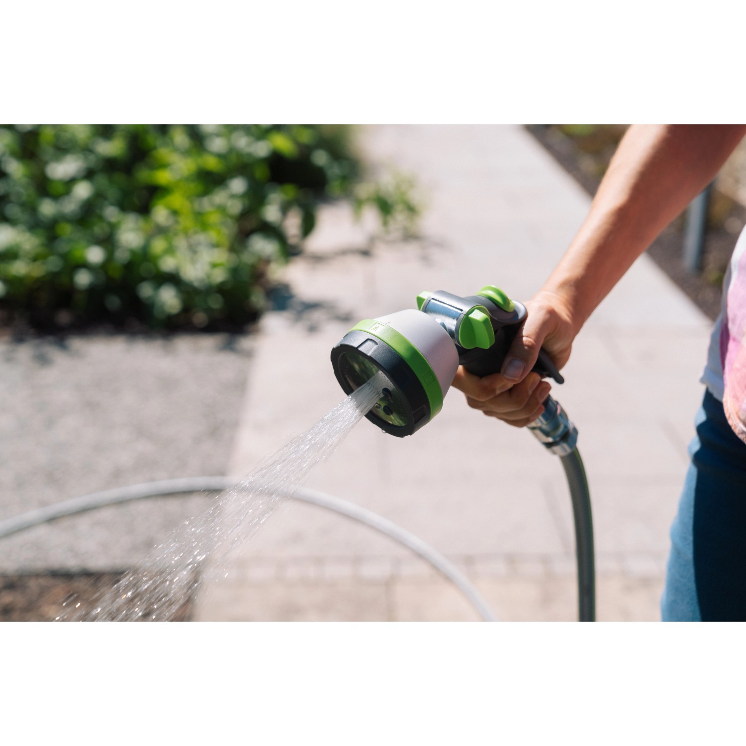 Geka Multibrause Plus 5S Grau in Aktion: Hand hält Gartenspritze mit Wasserstrahl.