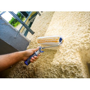 Hand streicht mit LUX Farbroller Grob 27 cm eine Wand. Farbrolle für Wandfarben.