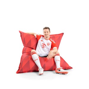 Roter Sitting Point Sitzsack BigBag FCB (380 l) mit Mann im Fußballtrikot.