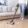 Ryobi Akku-Staubsauger RASV18BL-0 mit Wandstation im Einsatz auf Holzboden.