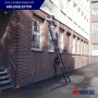 PROREGAL 3-in-1 Mehrzweckleiter/Anlegeleiter aus Aluminium mit Person bei Nutzung vor Gebäude.