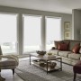 Drei weiße Seitenzugrollos zur Verdunkelung an Fenstern im Wohnzimmer. Blickdichter Sicht- und Sonnenschutz, ohne Bohren.