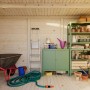 Innenansicht: Palmako Holz-Gartenhaus mit Pultdach, unbehandelt, mit Gartengeräten und Regalen.