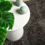 Anthrazitfarbener Hochflor Teppich Istan (120x170 cm) neben einem Tisch mit Dekoration.
