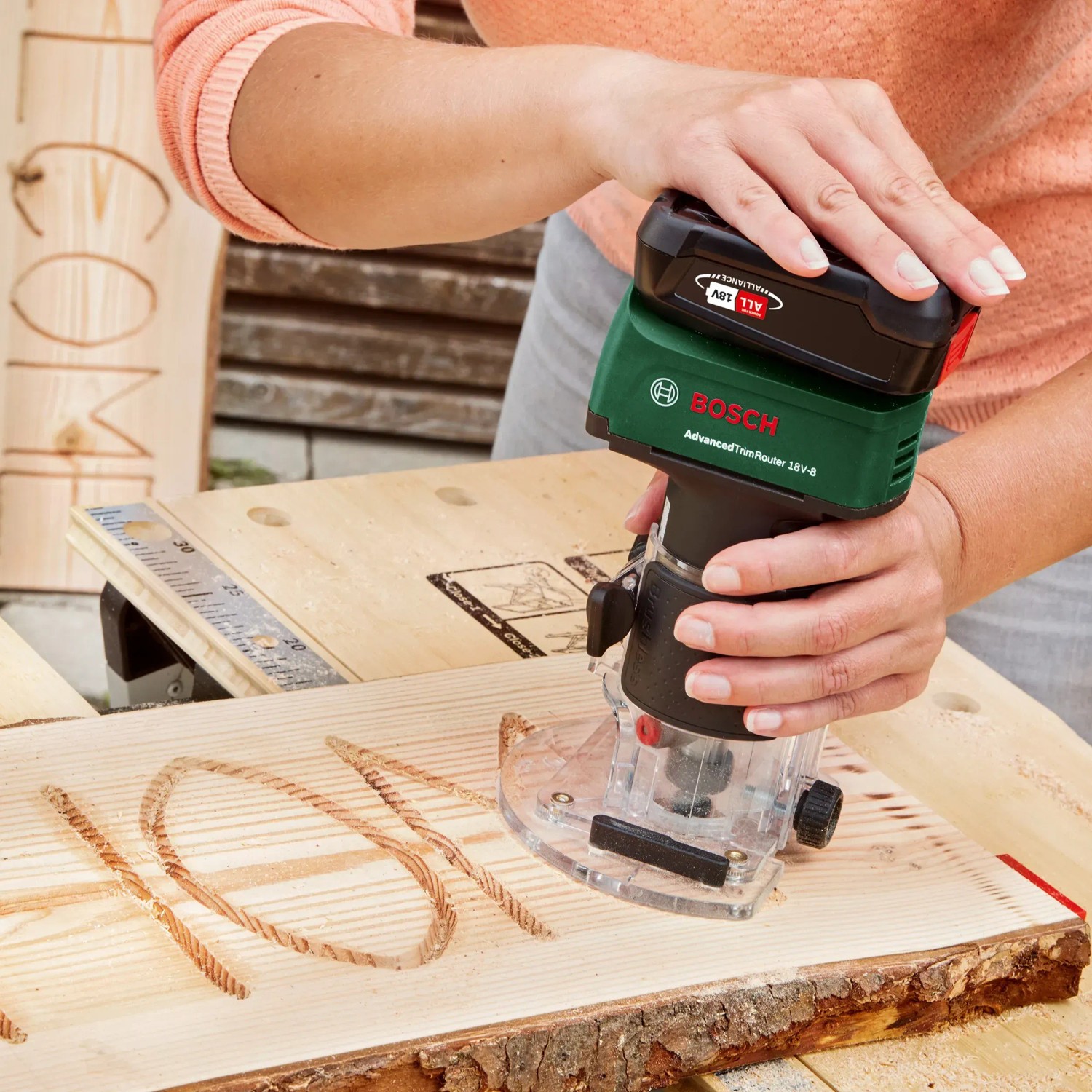 Bosch Akku-Oberfräse Advanced TrimRouter beim Fräsen von Holz.