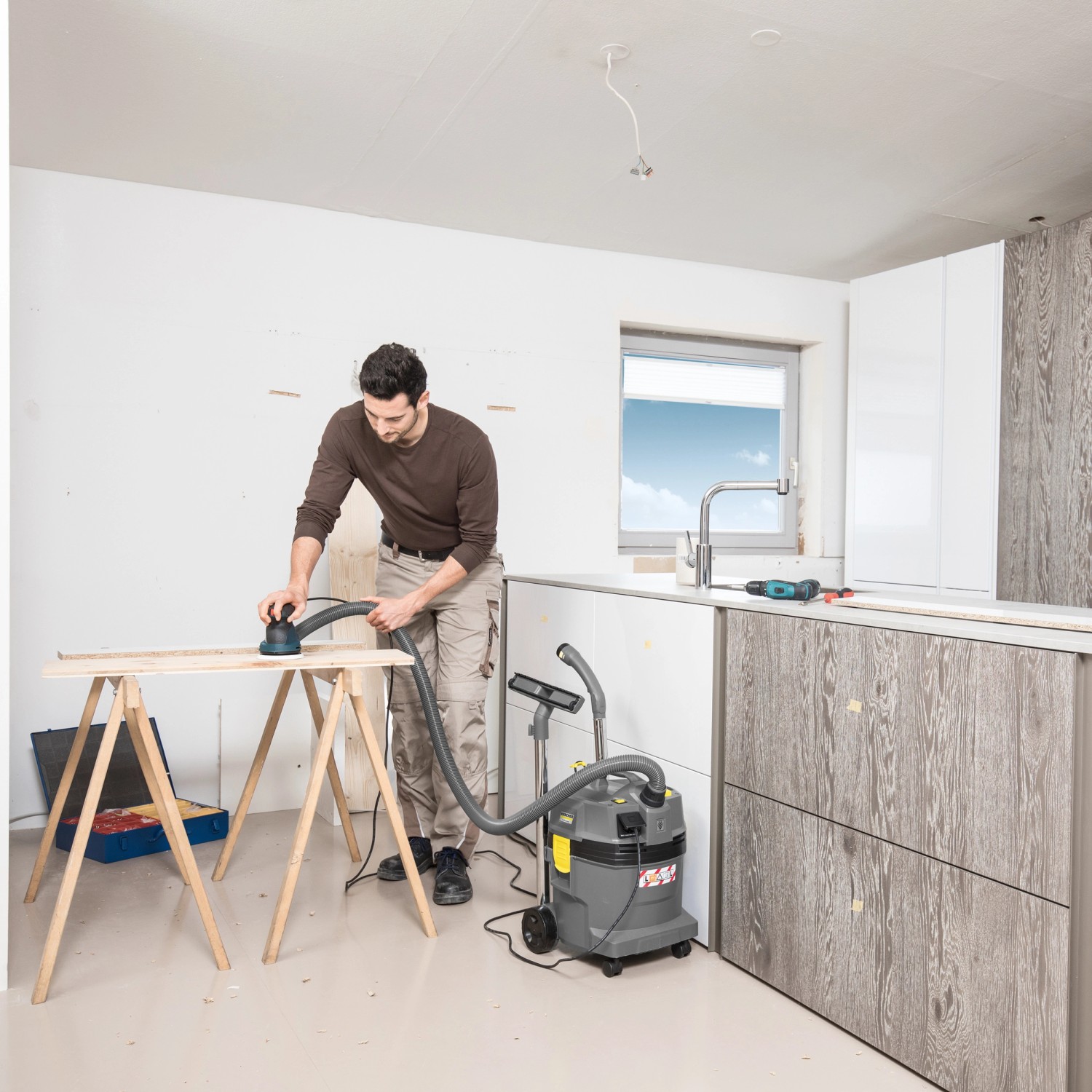 Mann schleift Holz mit Kärcher Nass-Trockensauger ProNT 600 L-Klasse im Einsatz.