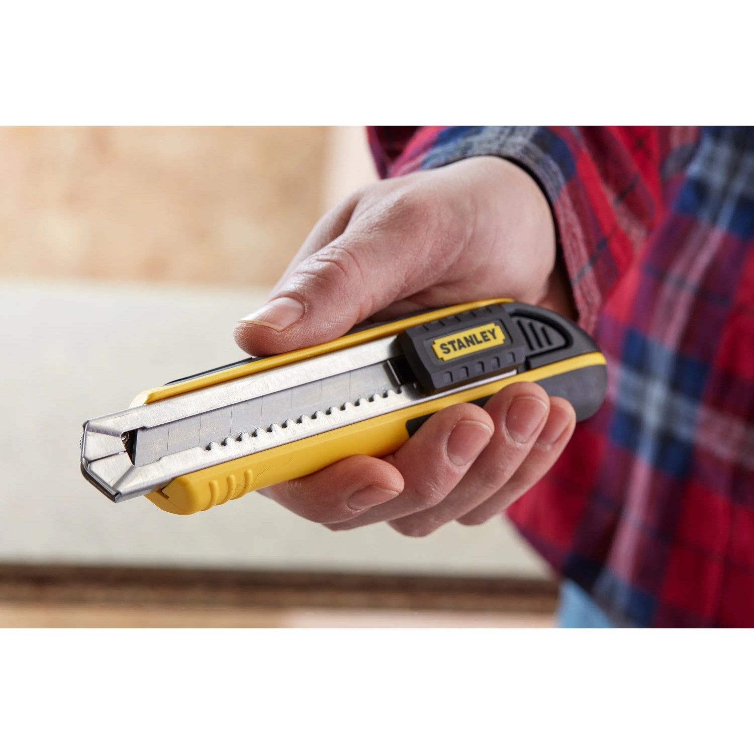 Stanley Cuttermesser FatMax 18mm in Schwarz-Gelb in Hand, Messer für präzise Schnitte.