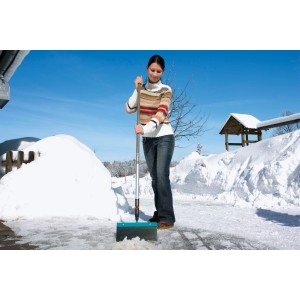 Frau benutzt Gardena combisystem Stoßscharre 30 cm zum Schneeräumen.