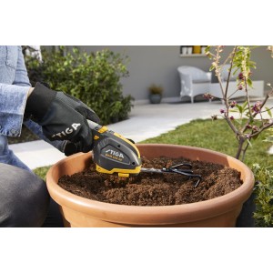 Stiga Grubber-Aufsatz für Gras- und Strauchschere im Einsatz in einem Blumentopf.