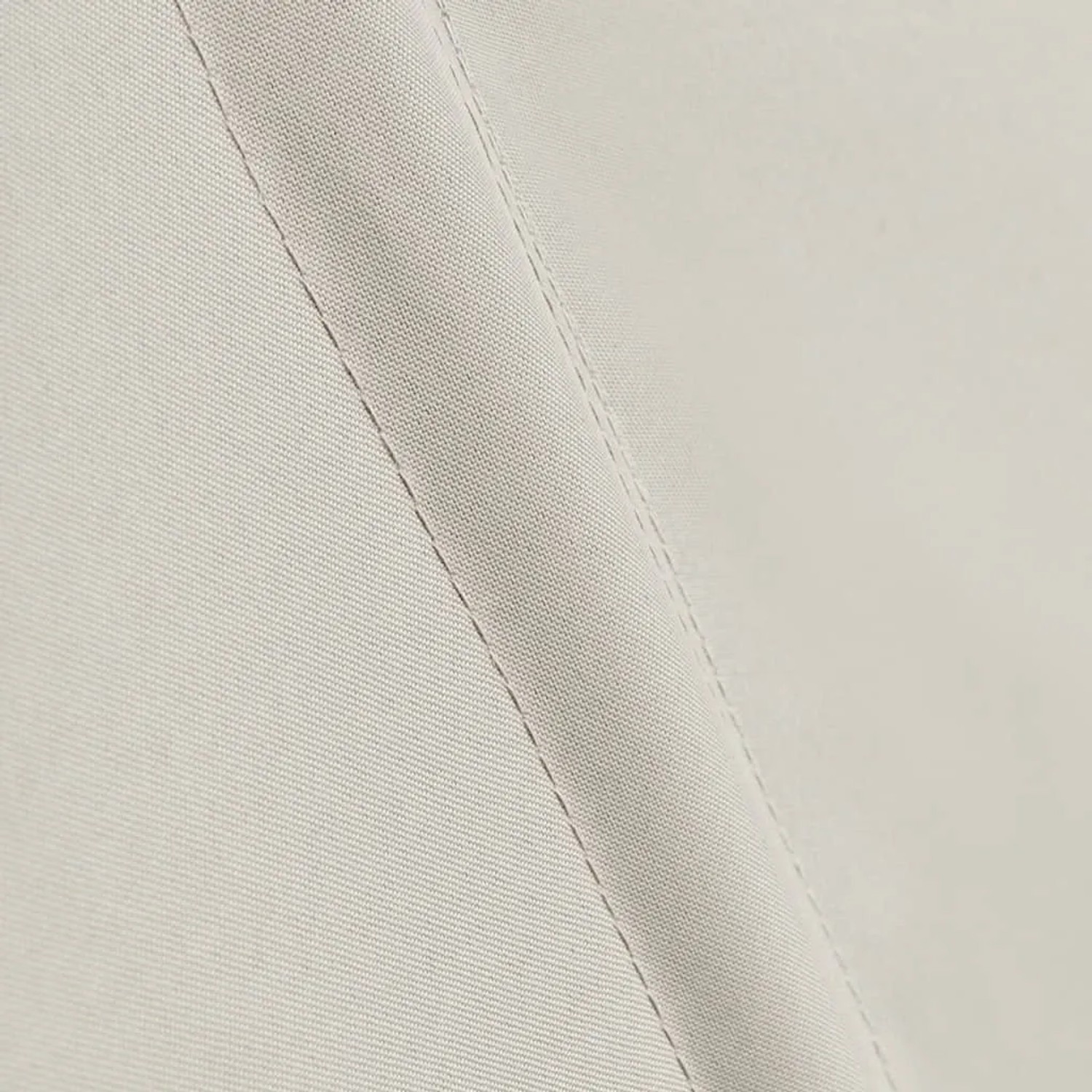 Detail des cremefarbenen Polyesterstoffs mit Naht für den faltbaren Balkonsichtschutz.