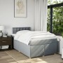 Helles Boxspringbett 120x200 cm mit Matratze und grauem Stoffbezug im Schlafzimmer.