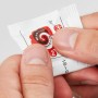 Detailaufnahme: Hände öffnen eine Packung Fischer Kleber für Klebehaken.