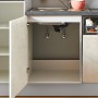 Detailansicht der pino Küchenzeile in Beton Weißgrau mit geöffnetem Spülenschrank.