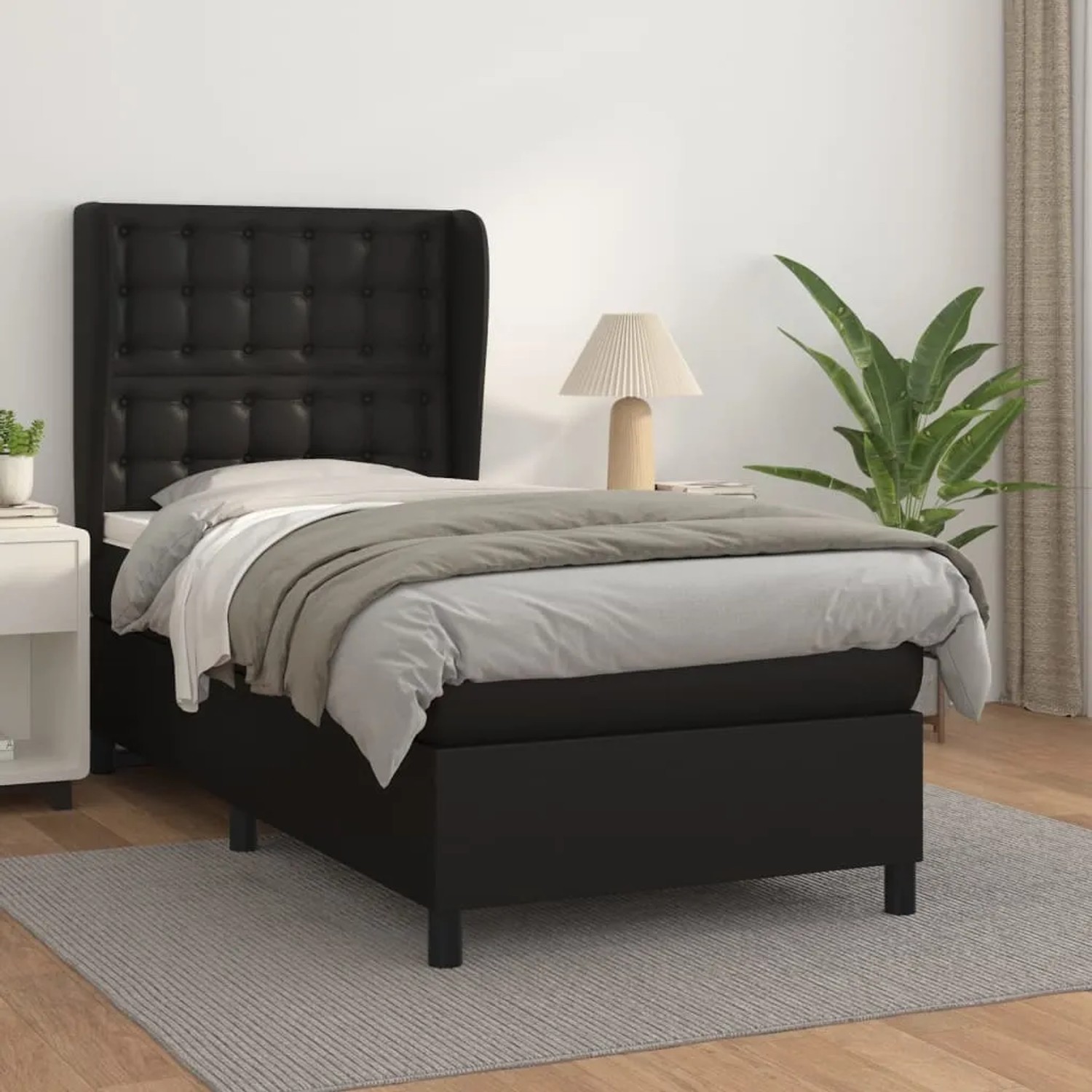 Schwarzes Boxspringbett (100x200 cm) mit Kunstlederbezug und Matratze für erholsamen Schlaf.